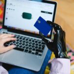 person holding blue card on macbook pro